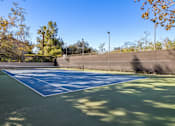Thumbnail 17 of 23 - A tennis and basketball court with a net and trees in the background at The Aspens Fairhaven, Santa Ana, 92705