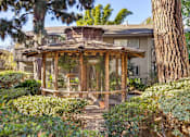 Thumbnail 19 of 23 - A wooden bird aviary is surrounded by green bushes at The Aspens Fairhaven, Santa Ana, 92705