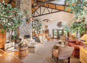 Thumbnail 36 of 42 - A clubhouse living room with a stone fireplace and wooden furniture at The Aspens South Coast, California, 92504