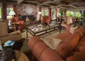 Thumbnail 26 of 30 - a clubhouse living room with couches and chairs and a fireplace