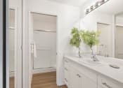 Thumbnail 6 of 30 - a bathroom with a sink and a mirror and a shower