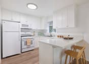 Thumbnail 4 of 30 - a kitchen with white cabinets and white appliances and a white counter top