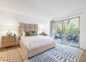 Thumbnail 5 of 30 - a bedroom with a large bed and a sliding glass door overlooking a private patio
