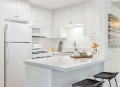 Thumbnail 17 of 30 - a white kitchen with a white counter top and a white refrigerator