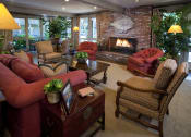 Thumbnail 14 of 19 - a clubhouse living room filled with furniture and a fireplace