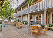 Thumbnail 12 of 23 - A patio with a table and chairs is surrounded by trees at The Aspens Fairhaven, Santa Ana, 92705