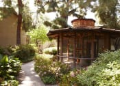 Thumbnail 16 of 19 - a bird aviary in a garden with plants and trees
