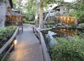 Thumbnail 11 of 17 - a wooden bridge over a pond in a garden at The Aspens Riverside, California, 92504