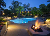 Thumbnail 1 of 30 - a swimming pool at night with a fire pit