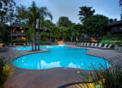 Thumbnail 23 of 30 - a swimming pool at night at an apartment community