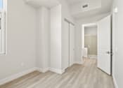Thumbnail 29 of 35 - a living room with white walls and a door to a bathroom