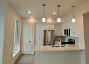 Thumbnail 12 of 88 - A kitchen with a white counter and a stainless steel refrigerator.