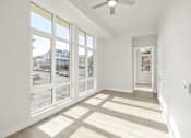 Thumbnail 23 of 35 - a living room with large windows and a ceiling fan