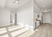 Thumbnail 25 of 35 - a living room with a kitchen and a ceiling fan