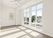 Thumbnail 28 of 35 - a living room with large windows and a ceiling fan