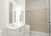 Thumbnail 22 of 35 - a white bathroom with a sink and a shower