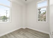 Thumbnail 16 of 35 - an empty room with a wooden floor and two windows