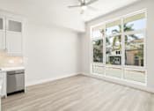 Thumbnail 15 of 35 - an empty living room with a large window and a kitchen