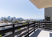 Thumbnail 29 of 88 - A balcony with a railing overlooks a cityscape.