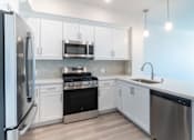 Thumbnail 25 of 88 - A modern kitchen with stainless steel appliances and white cabinets.
