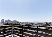 Thumbnail 47 of 88 - A balcony overlooks a cityscape and the ocean.