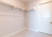 Thumbnail 38 of 88 - A white closet with a white door and a white shelf.
