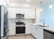 Thumbnail 42 of 88 - A modern kitchen with white cabinets and stainless steel appliances.
