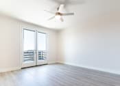 Thumbnail 43 of 88 - A room with a ceiling fan and sliding glass doors.
