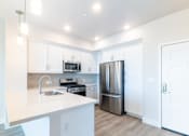 Thumbnail 40 of 88 - A modern kitchen with white cabinets and a stainless steel refrigerator.