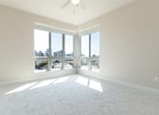 Thumbnail 56 of 88 - A spacious room with a ceiling fan and large windows overlooking a cityscape.