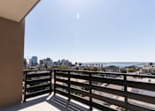 Thumbnail 57 of 88 - A balcony with a view of the city and the ocean.