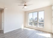 Thumbnail 60 of 88 - A room with a ceiling fan and a large window overlooking a cityscape.