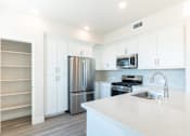 Thumbnail 64 of 88 - A kitchen with white cabinets and a stainless steel refrigerator.