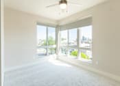 Thumbnail 67 of 88 - A room with a ceiling fan and large windows overlooking a cityscape.