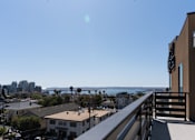 Thumbnail 70 of 88 - A balcony overlooks a residential area with a view of the ocean.