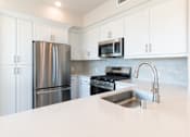 Thumbnail 77 of 88 - A kitchen with a stainless steel refrigerator, microwave, and oven.