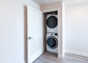 Thumbnail 68 of 88 - A washer and dryer are tucked into a small space in a home.