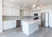 Thumbnail 35 of 88 - A kitchen with white cabinets and a large island.