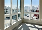 Thumbnail 20 of 88 - A sunny day in a room with large windows overlooking a cityscape.