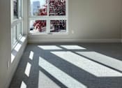 Thumbnail 21 of 88 - A room with a ceiling fan and a large window overlooking a tree-filled outdoor area.