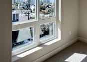Thumbnail 23 of 88 - A room with a large window overlooking a cityscape.