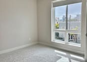Thumbnail 14 of 88 - A room with a ceiling fan and a large window showing an outdoor view.