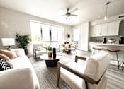 Thumbnail 4 of 88 - A living room with a white couch, a coffee table, and a ceiling fan.