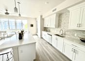 Thumbnail 7 of 88 - A kitchen with white cabinets and a large island.