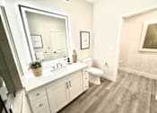 Thumbnail 86 of 88 - A bathroom with a white sink and a large mirror.