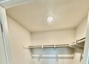 Thumbnail 87 of 88 - A small, empty closet with a carpeted floor and white walls.