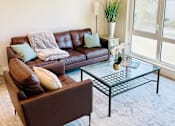Thumbnail 33 of 35 - a living room with leather furniture and a glass coffee table
