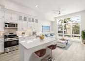 Thumbnail 3 of 35 - an open kitchen and living room with white cabinets and stainless steel appliances