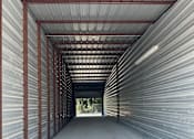 Thumbnail 11 of 11 - The inside of a 14x60 storage unit with clean concrete floor and metal walls.