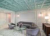 Thumbnail 5 of 8 - a living room with gray couches and a glass coffee table